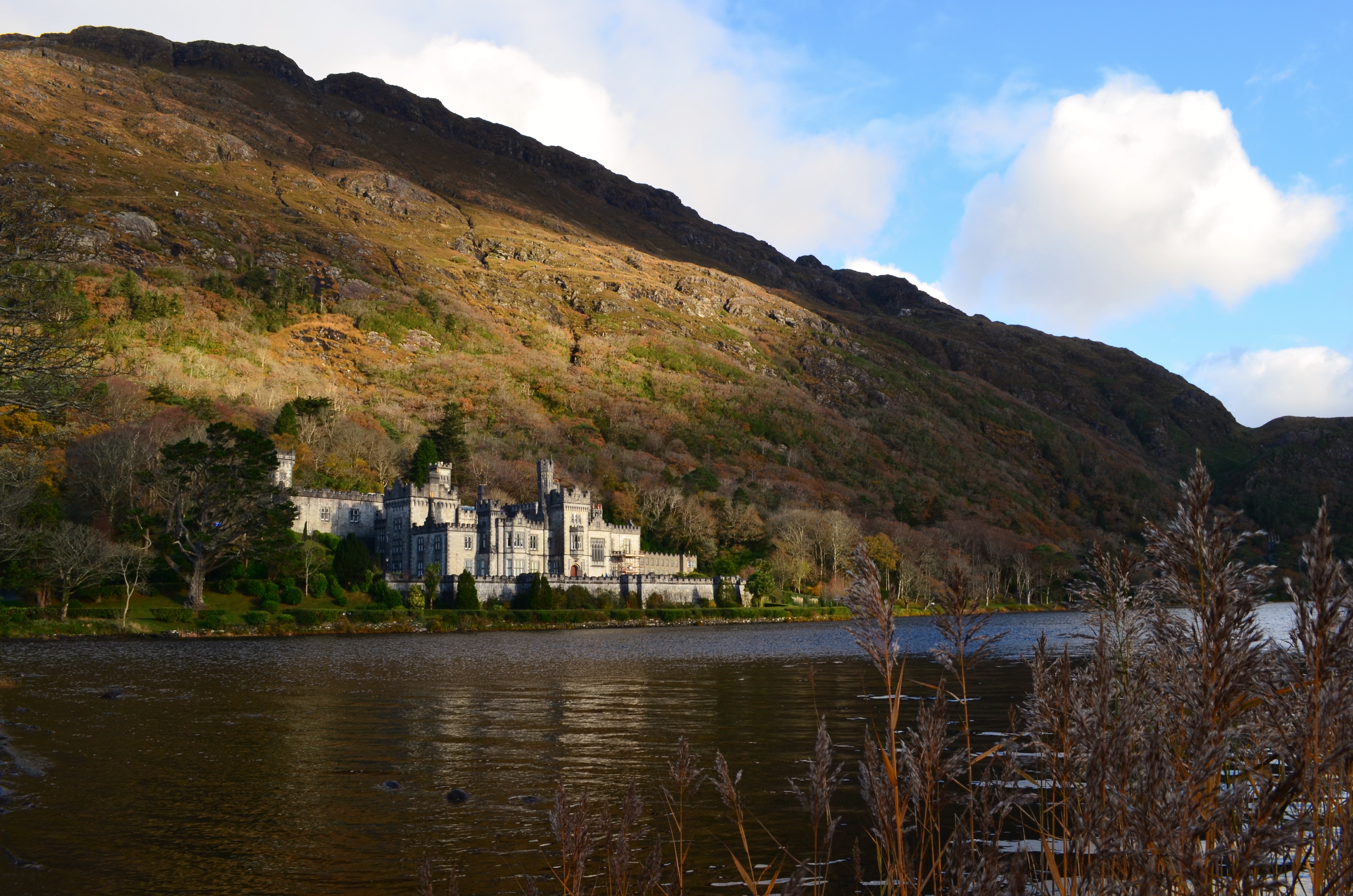 Sun catching the turrets of Kylemore Abbey across Lough Pollacapall